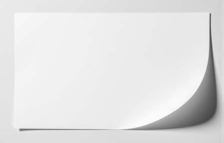 Elegant white paper with turned up corner edge shadow on plain background minimal mockup layout for adding design logo text content printの写真素材