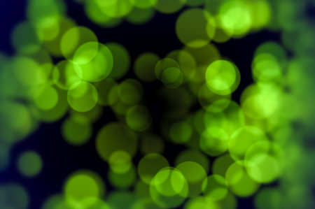 Soft green light bubbles on black background perfect for nature inspired visuals freshness concepts celebration design and spring environmental projectsの写真素材