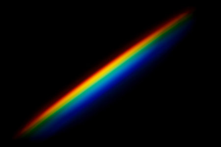 Diagonal bright rainbow light beam on black background for overlay, abstract colorful spectrum for science design fantasy art technology themesの写真素材