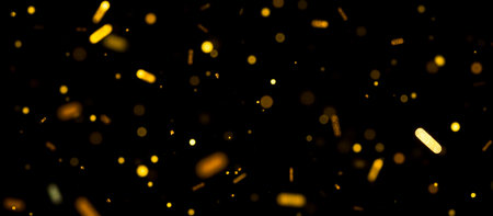 falling gold confetti overlay on dark black background, sparkling effect overlay for event designs, celebration or holiday atmosphere with glowing glitter, festive background for partyの写真素材