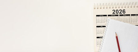 Blank notepad and 2026 calendar on white background. Mockup for writing yearly business plans, schedules, and new year's resolutions and goalsの写真素材