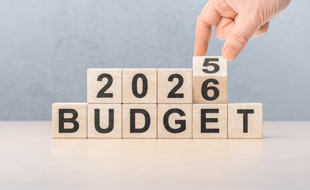 Man completes 2026 number above the word BUDGET. Symbolizes financial goals, annual economic...