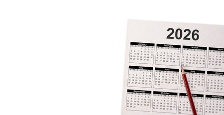 Concept of scheduling and planning for 2026. Closeup of pencil on calendar grid for business...