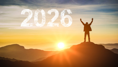 2026 New Year. Silhouette of happy person on a peak watching the sunrise. Represents hope, new...