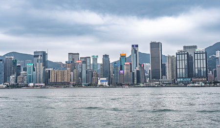 HONG KONG CHINA - DECEMBER 29 2025: View of Hong Kong island skyline Victoria Harbor tall office buildings financial district architecture asian metropolis travel business tourismの写真素材