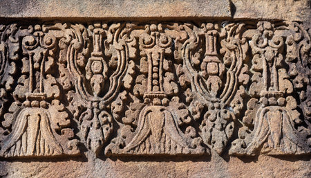 Intricate stone carving floral pattern bas relief pink sandstone ancient Khmer art temple decoration history architecture archeology detail weathered background concept travel landmarkの写真素材