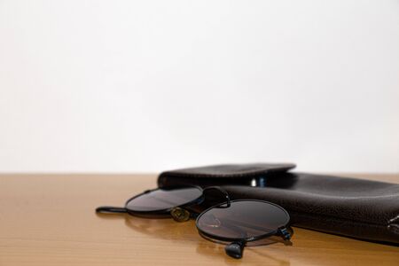 Glasses and brown case on a wooden tableの写真素材