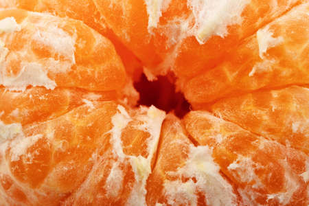 Slices of a ripe tangerine are fancifully placed on a white backgroundの写真素材