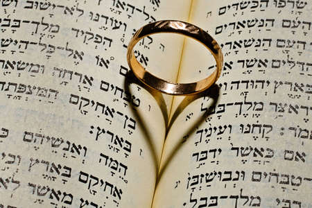 Wedding ring gives the shadow of the heart in the Bible open at the Solomon's Song of Solomonの写真素材