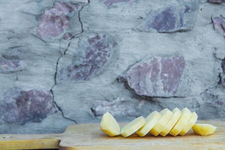 sliced ??potatoes on a wooden boardの写真素材