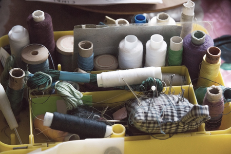 skeins of threads and needles in a box