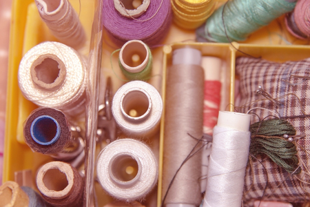 skeins of threads and needles in a box