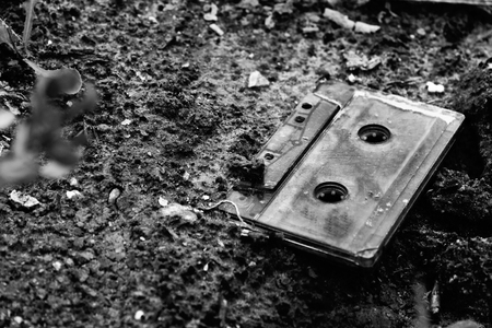 the old abandoned compact cassette in the sandの写真素材
