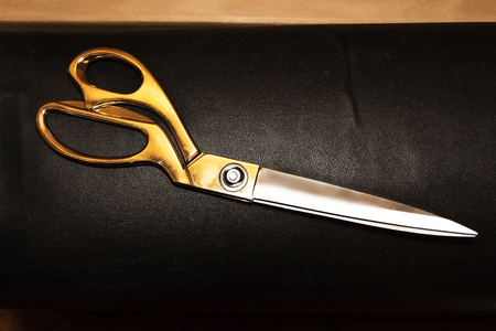 Vintage scissors on the background of genuine leather