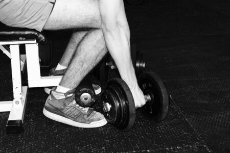 man lifts dumbbells at the gym