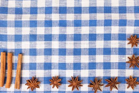 anise and cinnamon on a blue napkin, wooden background