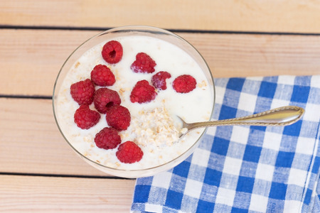 oatmeal with raspberries on a wooden background. breakfastの写真素材
