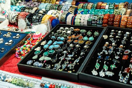 beautiful jewelry made of precious stones on a shelf in a storeの写真素材