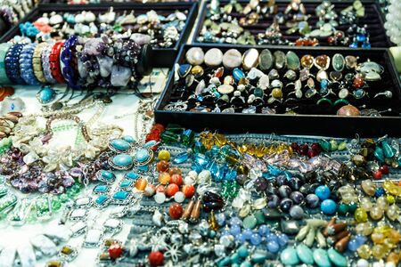 beautiful jewelry made of precious stones on a shelf in a storeの写真素材
