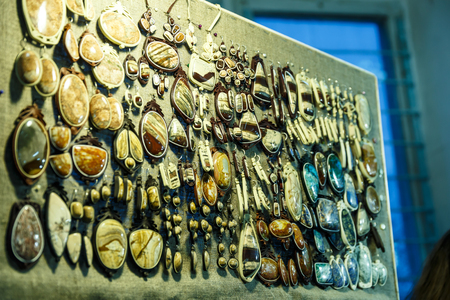 beautiful jewelry made of precious stones on a shelf in a storeの写真素材