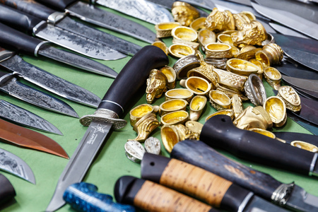 Hunting knives and knifes of large and small sizes lie on a table in a hunting and fishing store