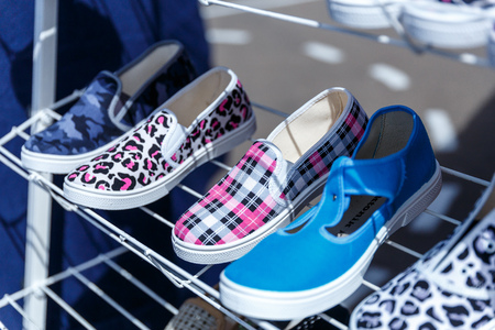 Men's women's and children's summer shoes lie on store shelvesの写真素材