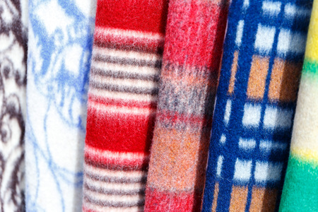 Wool blankets and plaids on the stand in the bed-clothes store