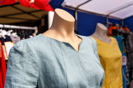 Summer female dress hanging on a mannequin in a women's clothing store on the street