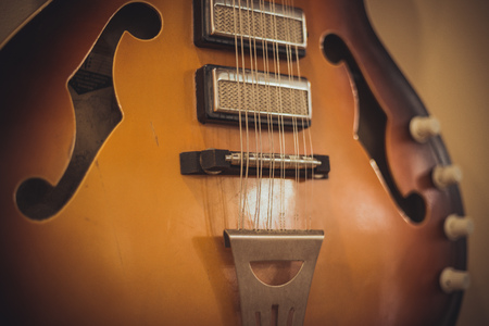 Retro bass guitar in vintage style on shelves in a musical instrument store