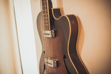 Retro bass guitar in vintage style on shelves in a musical instrument store