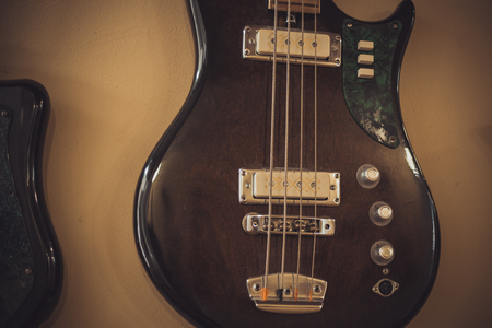 Retro bass guitar in vintage style on shelves in a musical instrument storeの写真素材