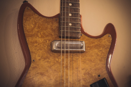 Retro bass guitar in vintage style on shelves in a musical instrument store
