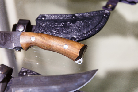 Hunting knives in harnesses lie on a shelf in a hunting shopの写真素材