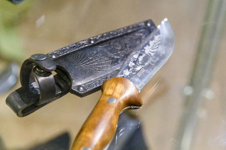 Hunting knives in harnesses lie on a shelf in a hunting shopの写真素材