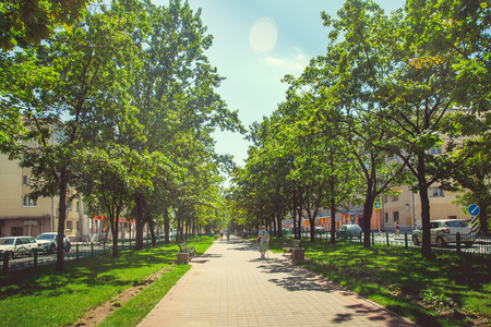 Green square in the center of the city in bright sunny dark weatherのeditorial素材
