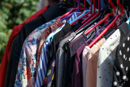 Hangers with men's and women's clothing at the garage saleの写真素材