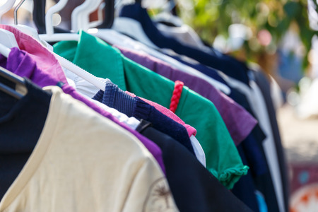 Hangers with men's and women's clothing at the garage saleの写真素材