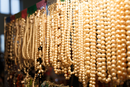 Beads, baubles and bracelets with precious stones and pearls hang in a jewelry store shopの写真素材
