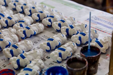 girl paints Christmas toys at a factory of Christmas toysの写真素材