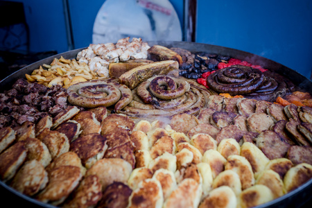a huge dish on which roasted sausage meat lard and potato pancakes