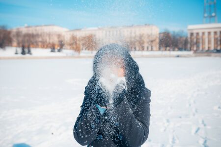 MINSK, BELARUS - February 1, 2017: red-hair woman blowing snow in hands in slow motionのeditorial素材