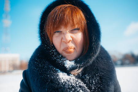 MINSK, BELARUS - February 1, 2017: red-hair woman blowing snow in hands in slow motionのeditorial素材