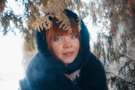 MINSK, BELARUS - February 1, 2017: Beautiful red hair girl in winter park with snowのeditorial素材