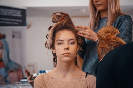 MINSK, BELARUS - MAY 1, 2017: The hairdresser does hair extensions to a young girlのeditorial素材