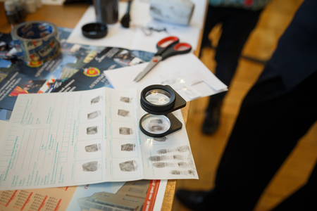 Criminology expert through a magnifying glass looking at a fingerprintの写真素材