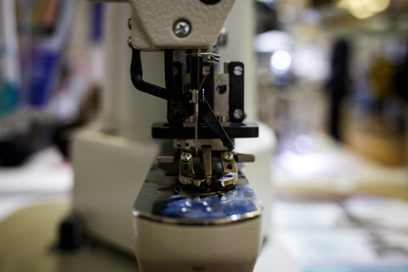 An automatic sewing machine sews with colored threads and precision in making any shape or design. Concept of: automatic, robot, sewing, tailoring, industry.の写真素材