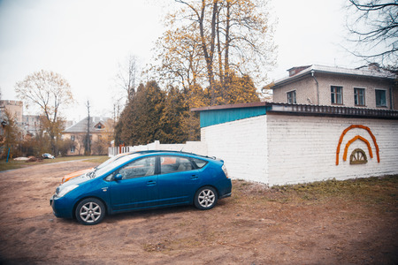 Authentic yard in poor Eastern Europe. Old wooden cottage and retro vintage car is in the barn. Abandoned and desolated vehicle.の写真素材