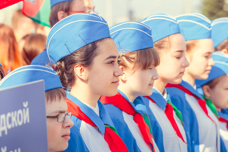 MINSK, BELARUS - MAY 1, 2017: Pupils-pioneers with pioneer neckties do salute on event for initiation for pioneers. Red flags in their hands.のeditorial素材