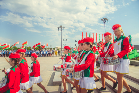 MINSK, BELARUS - MAY 1, 2017: Pupils-pioneers with pioneer neckties do salute on event for initiation for pioneers. Red flags in their hands.のeditorial素材