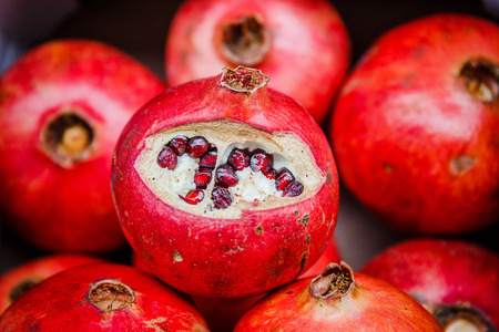 Red garnet, semi-cleaned, lies the shell of other pomegranates on the marketの写真素材
